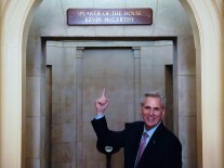 Newly-elected Speaker of the House Kevin McCarthy points to a newly installed sign above his office